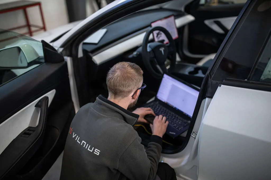 Meistras kompiuteriu atlieka Tesla automobilio diagnostiką „TS Vilnius“ servise